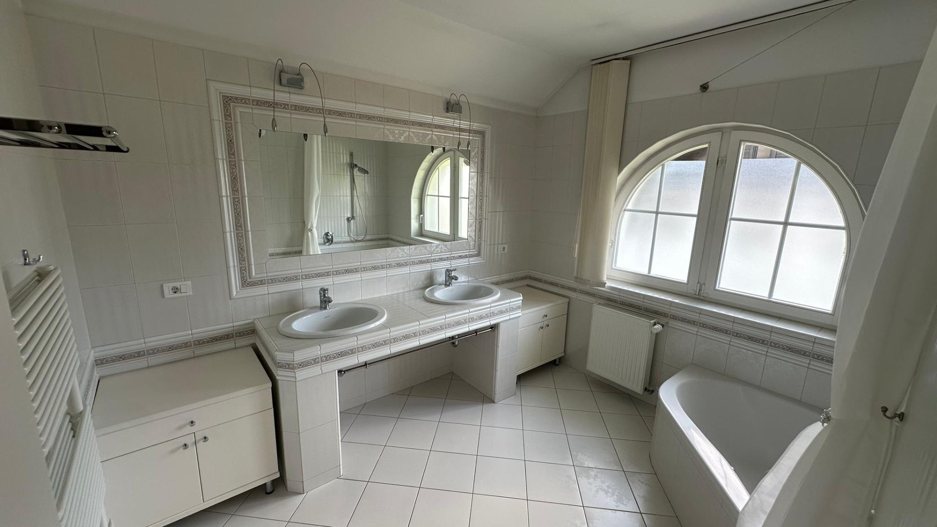 Spacious bathroom with double sink and bathtub